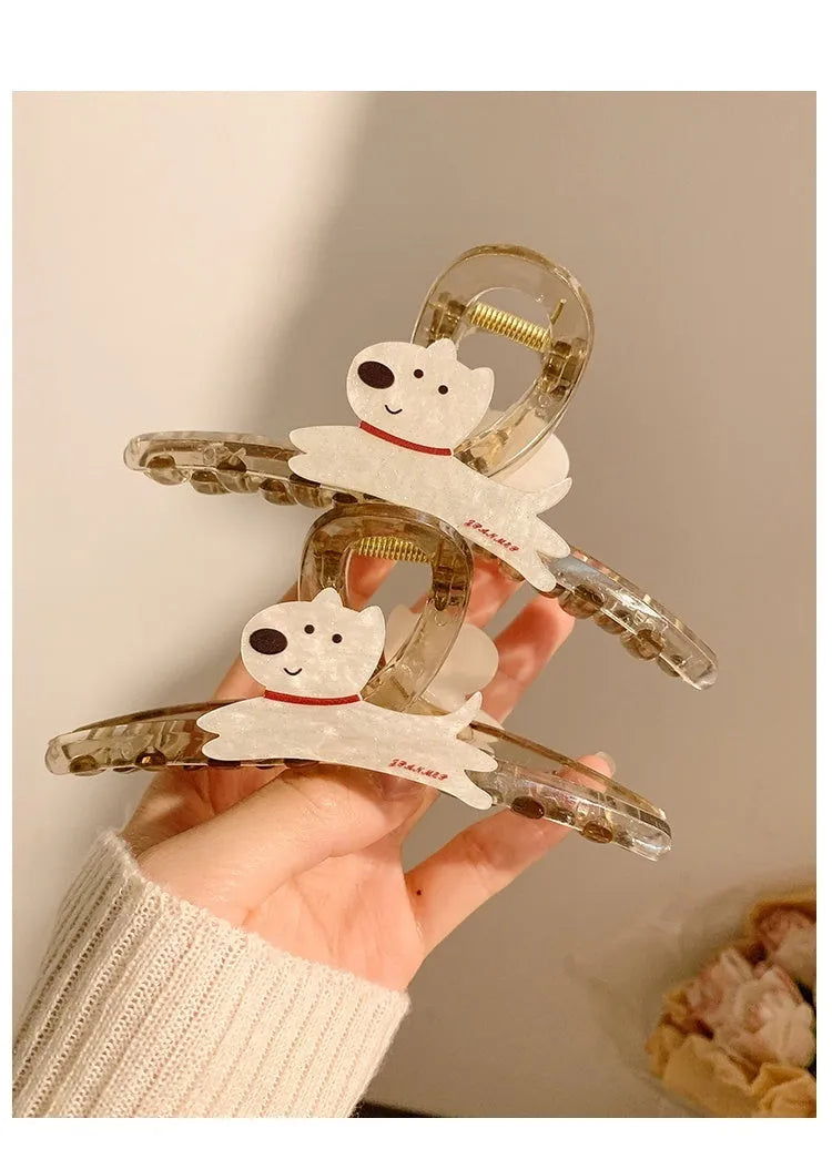 Beige and brown cartoon puppy-shaped hair grip barrettes on a white background.