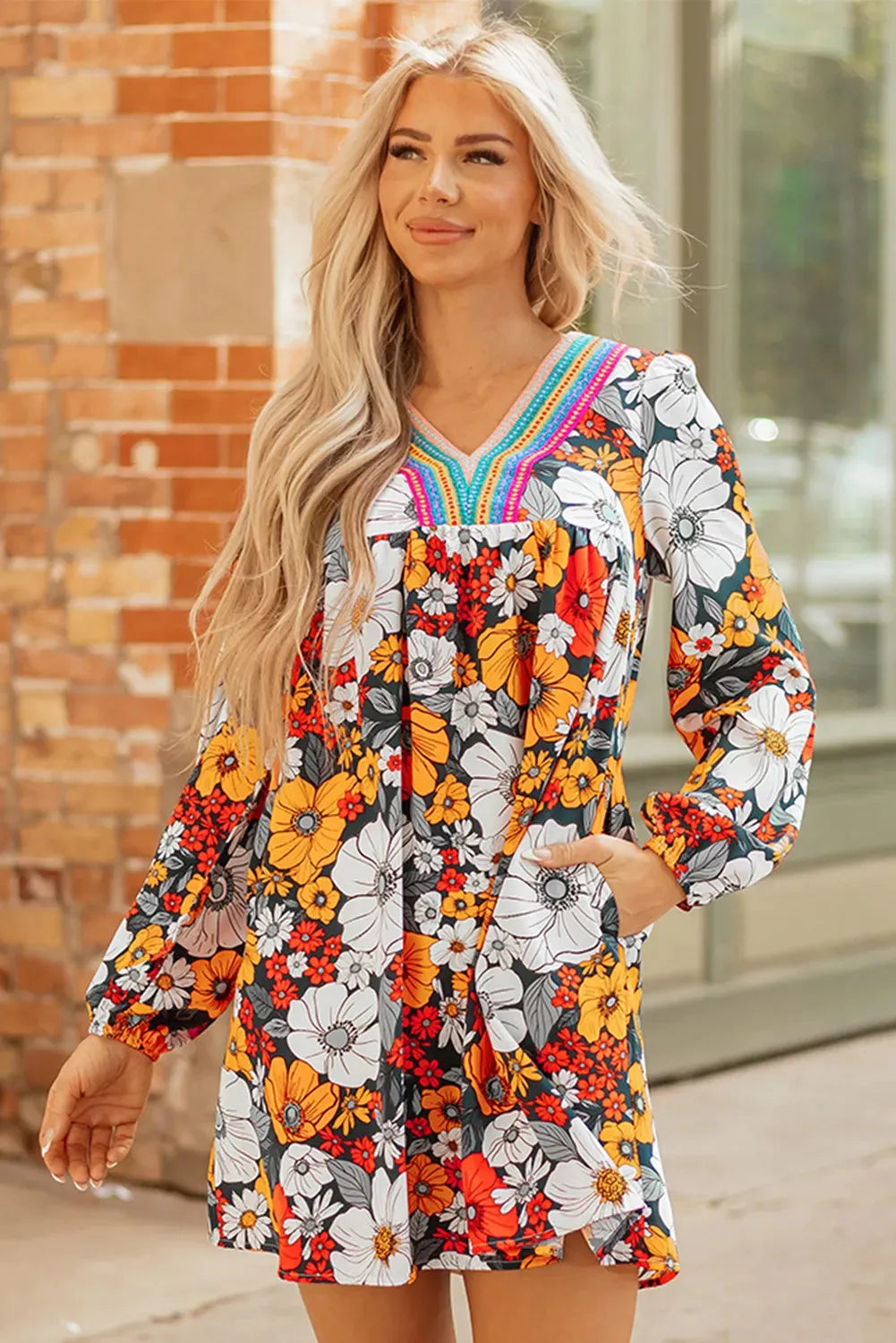 Orange floral print mini dress with lace trim, V-neck, and long sleeves on a hanger.