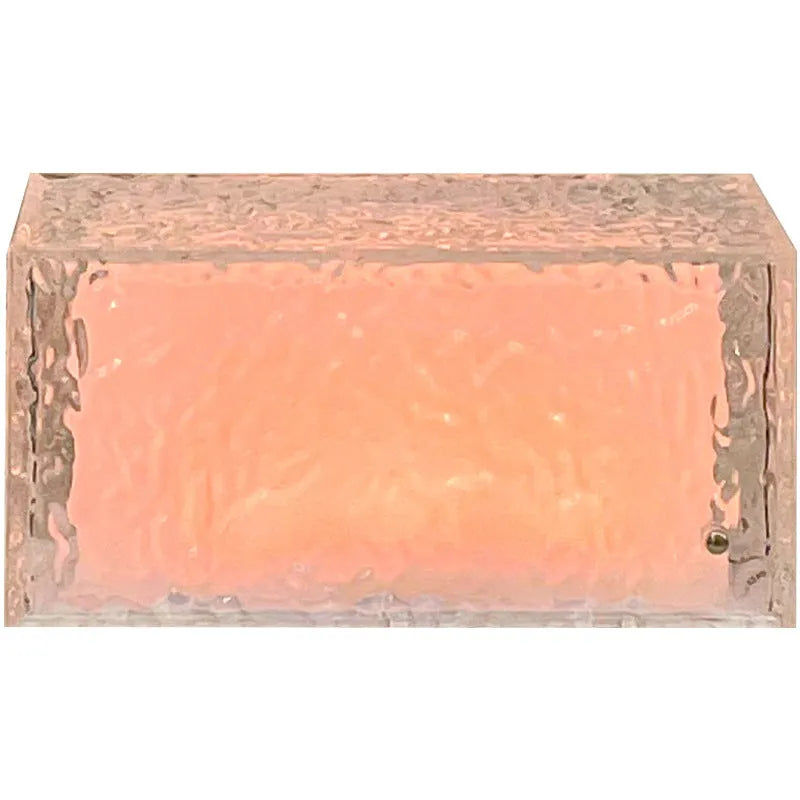 Clear acrylic geometric ice cube shaped night lamp glowing with soft blue LED light on a dark surface.