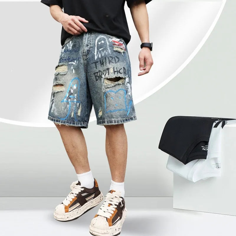 Blue men's ripped denim shorts with graffiti design and straight leg.