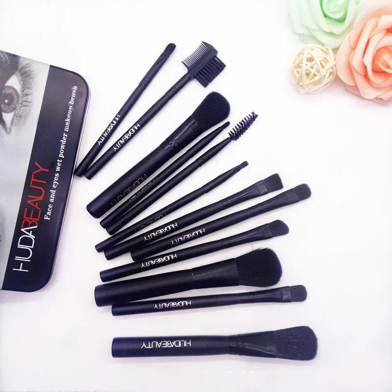 12 black makeup brushes in a tin box with nylon bristles and wooden handles on a white background