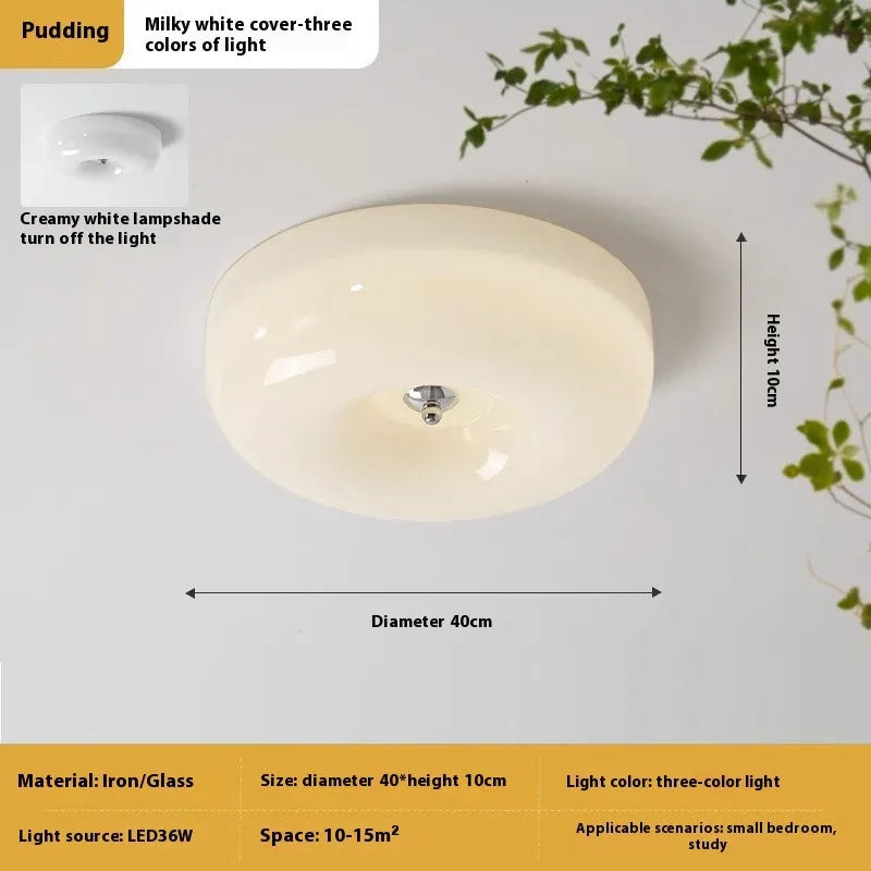 Creamy yellow and white opal shade ceiling light with remote control on a bedroom ceiling.