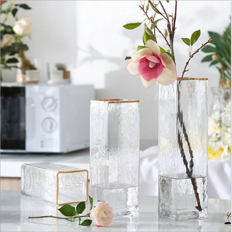 Transparent gold-painted glass vase on plain background