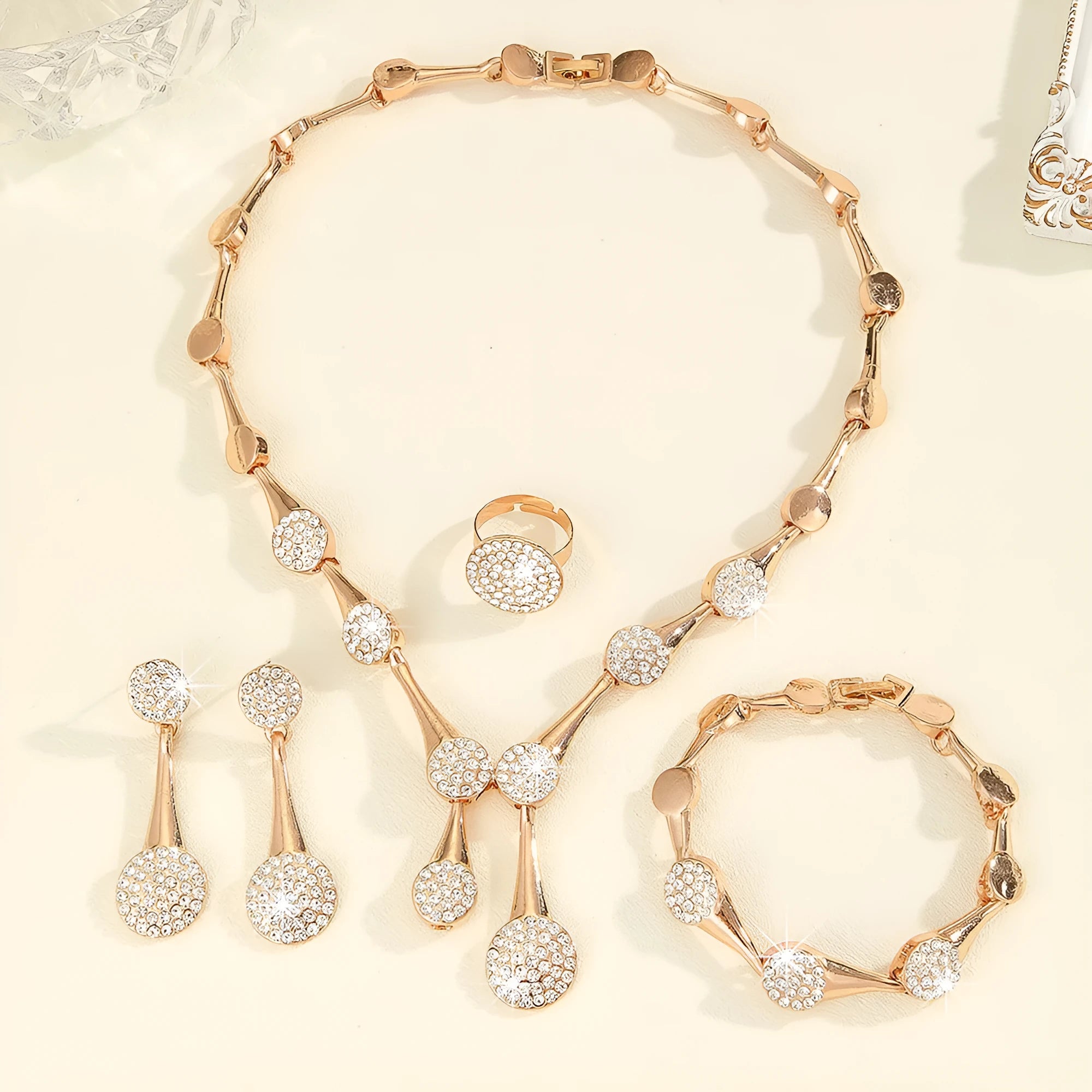 Gold alloy necklace earrings and bracelet set with bow and fan motifs on a light background