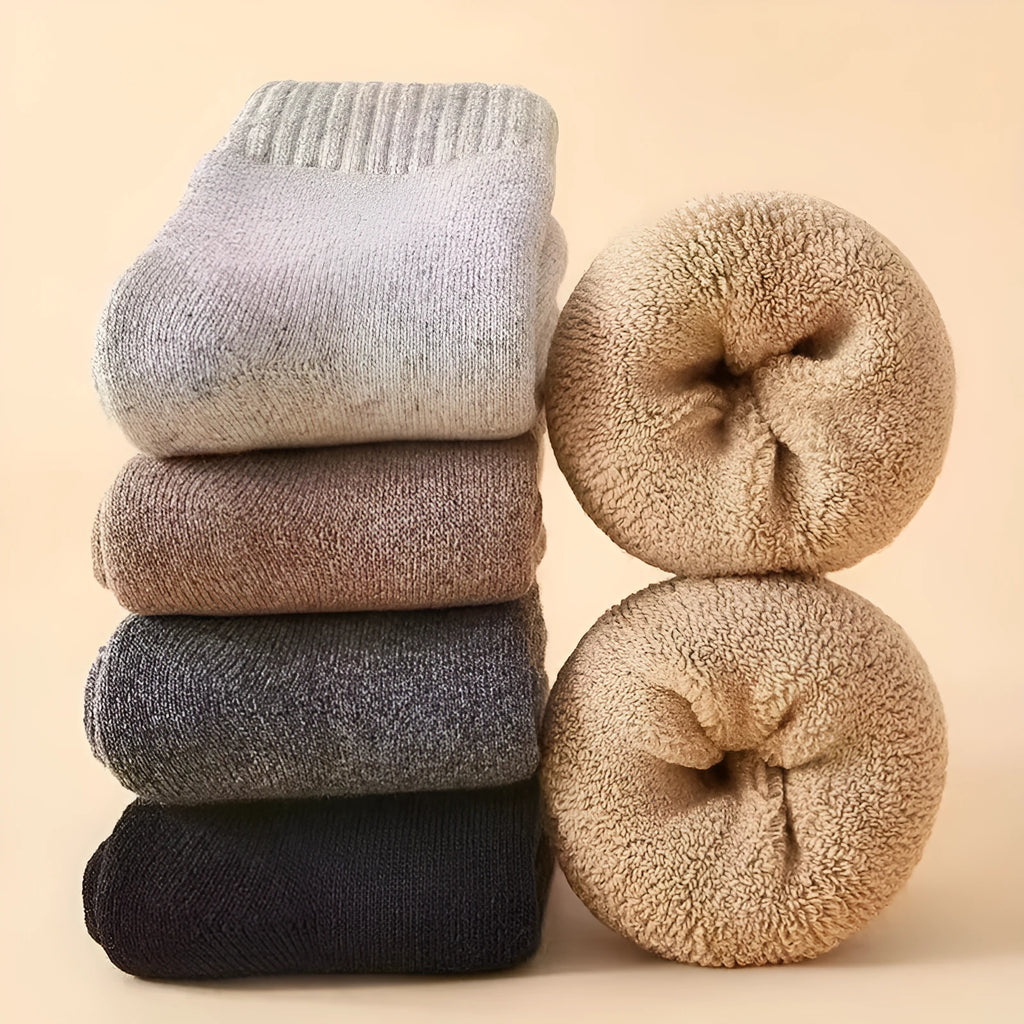 Pair of thick grey wool socks with a reinforced merino wool midsole for winter, presented in a box.