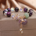 Women's forest style bracelet with purple tiger eye money bag pendant and rhinestone crystal details