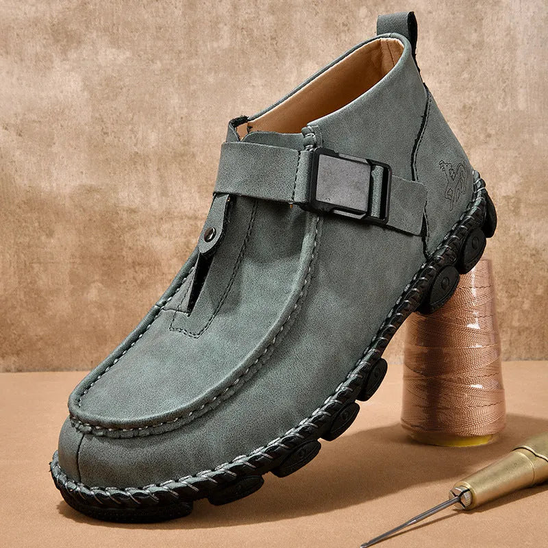 Men's black synthetic leather slip-on shoes with visible handmade stitching and a flat sole