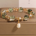 Adjustable green phantom quartz and champagne crystal bead bracelet on a string cord.
