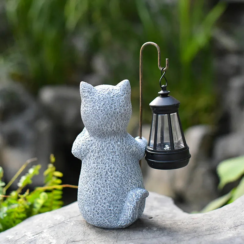 Solar-powered garden light with decorative resin kitten ornament lifting a lamp.