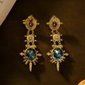 A pair of round geometric stud earrings with a gold finish and retro court style design.