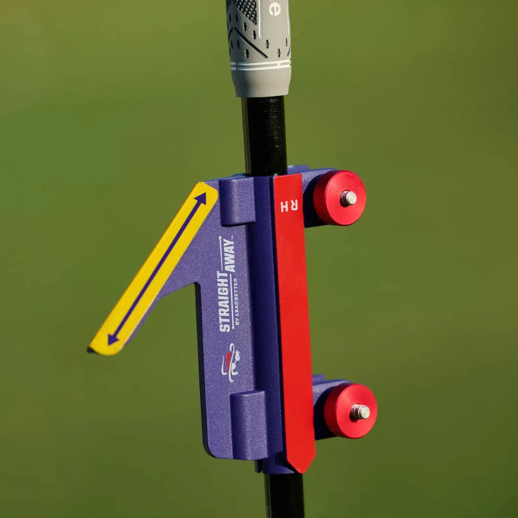 Plastic golf swing plane simulator trainer on a practice mat.