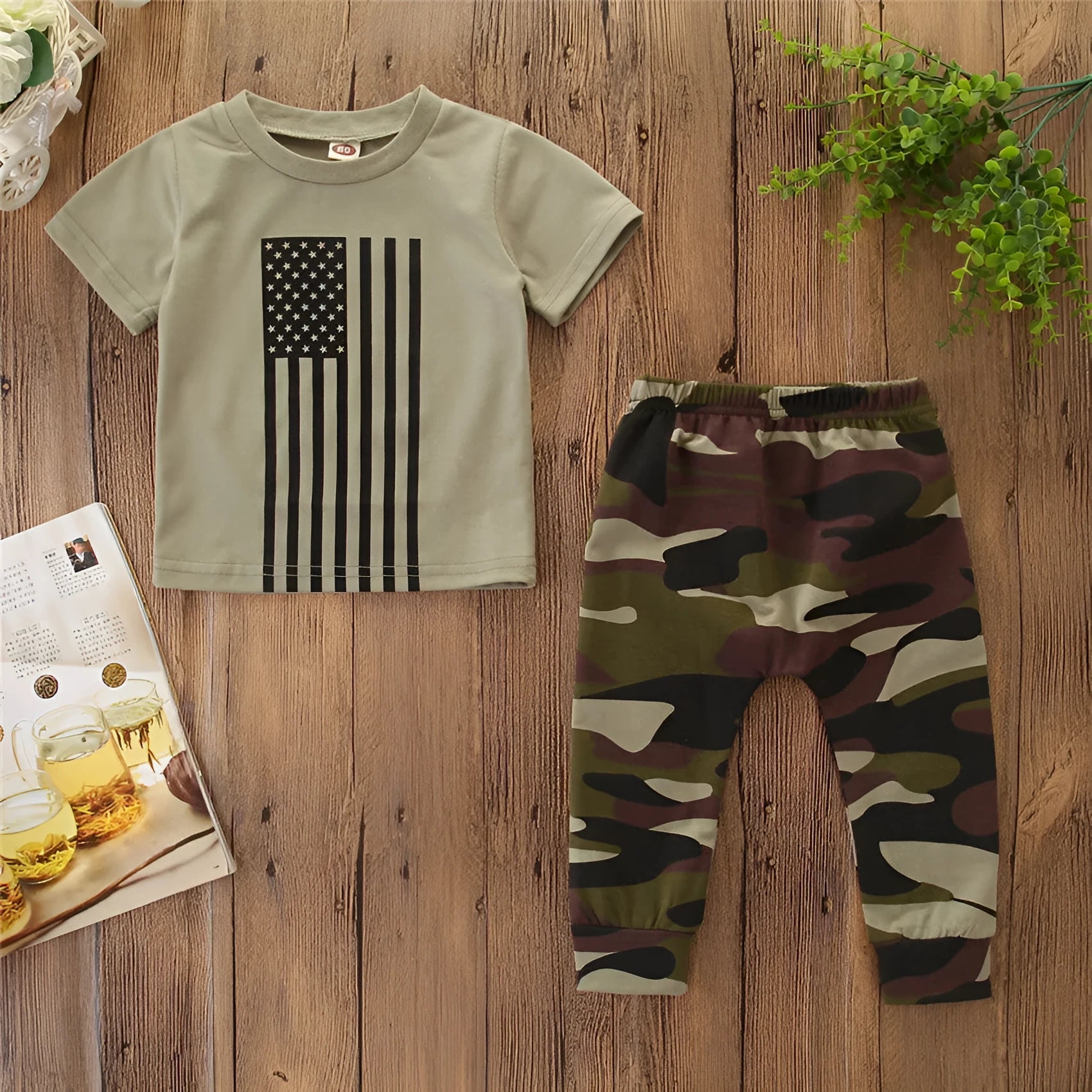 Little boy wearing a US flag camouflage print short-sleeved shirt and matching trousers.
