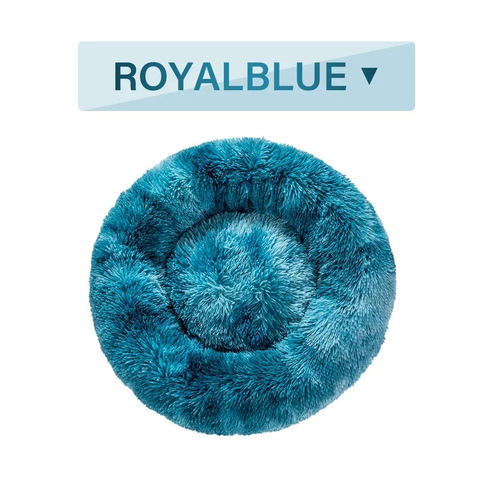 Fluffy donut-shaped pet bed in long plush fabric, shown in a light grey colour with a raised edge.
