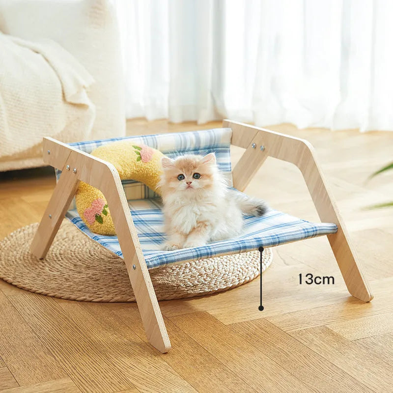 Wooden elevated cat bed with blue cloth hammock suspended inside frame
