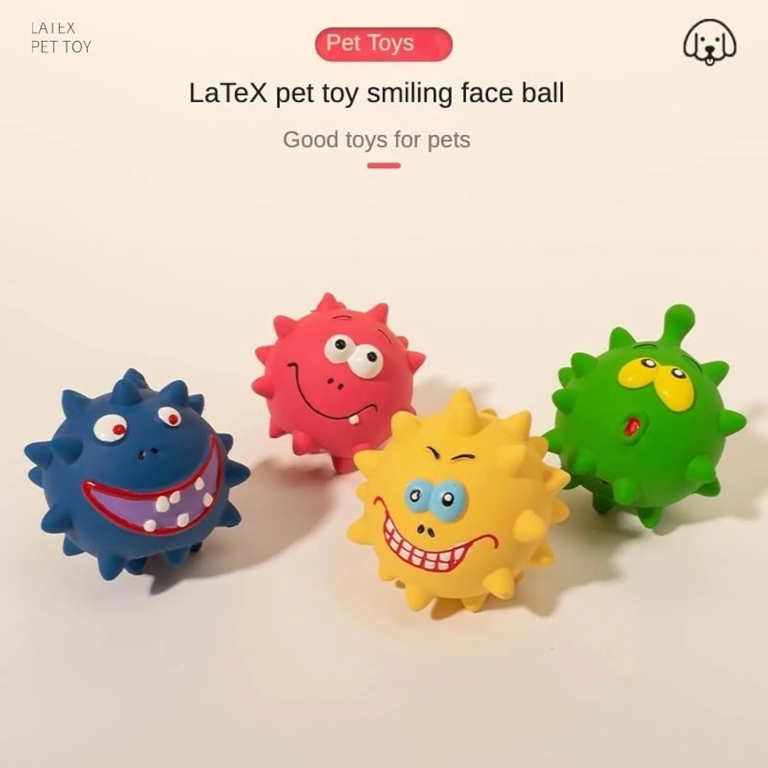 Set of four colourful latex squeaky dog balls with cute faces on a textured surface.