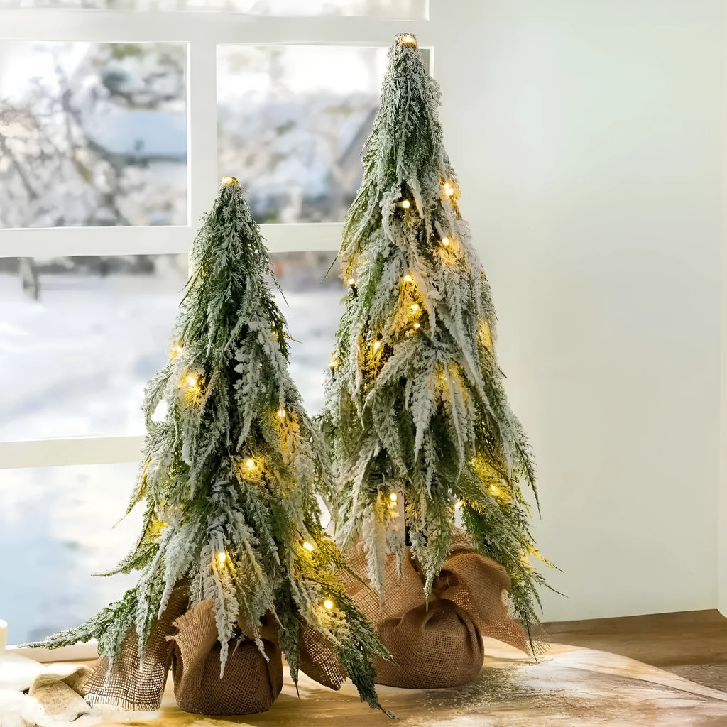 Small 24-inch white artificial Christmas tree with lights and snow spray on a desktop