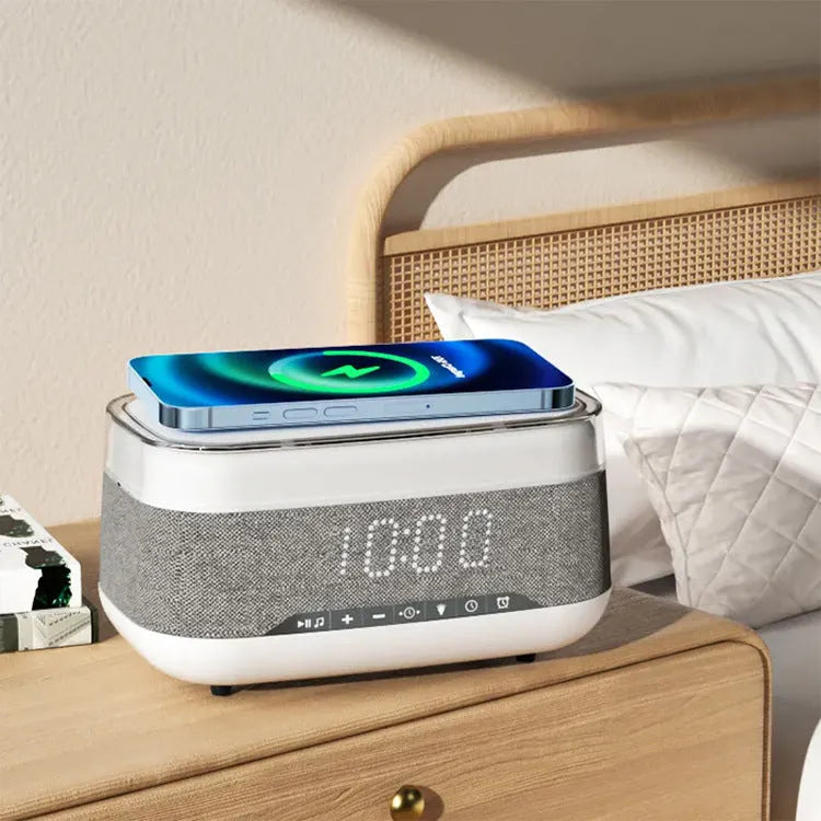 White multifunctional alarm clock with Bluetooth speaker and wireless charging pad showing night light illumination