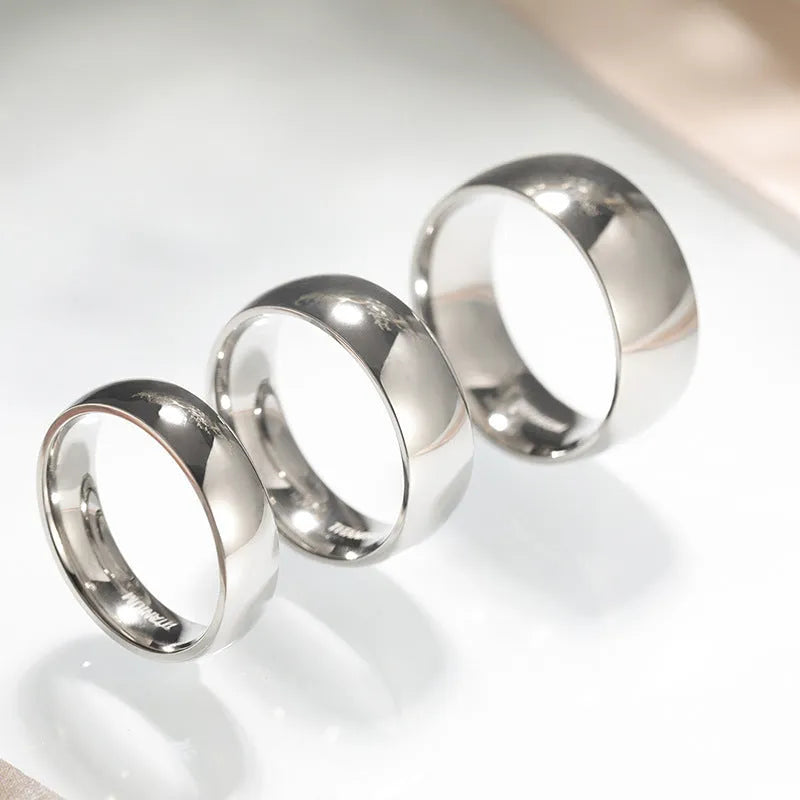Polished silver titanium ring showing different width options on a finger.