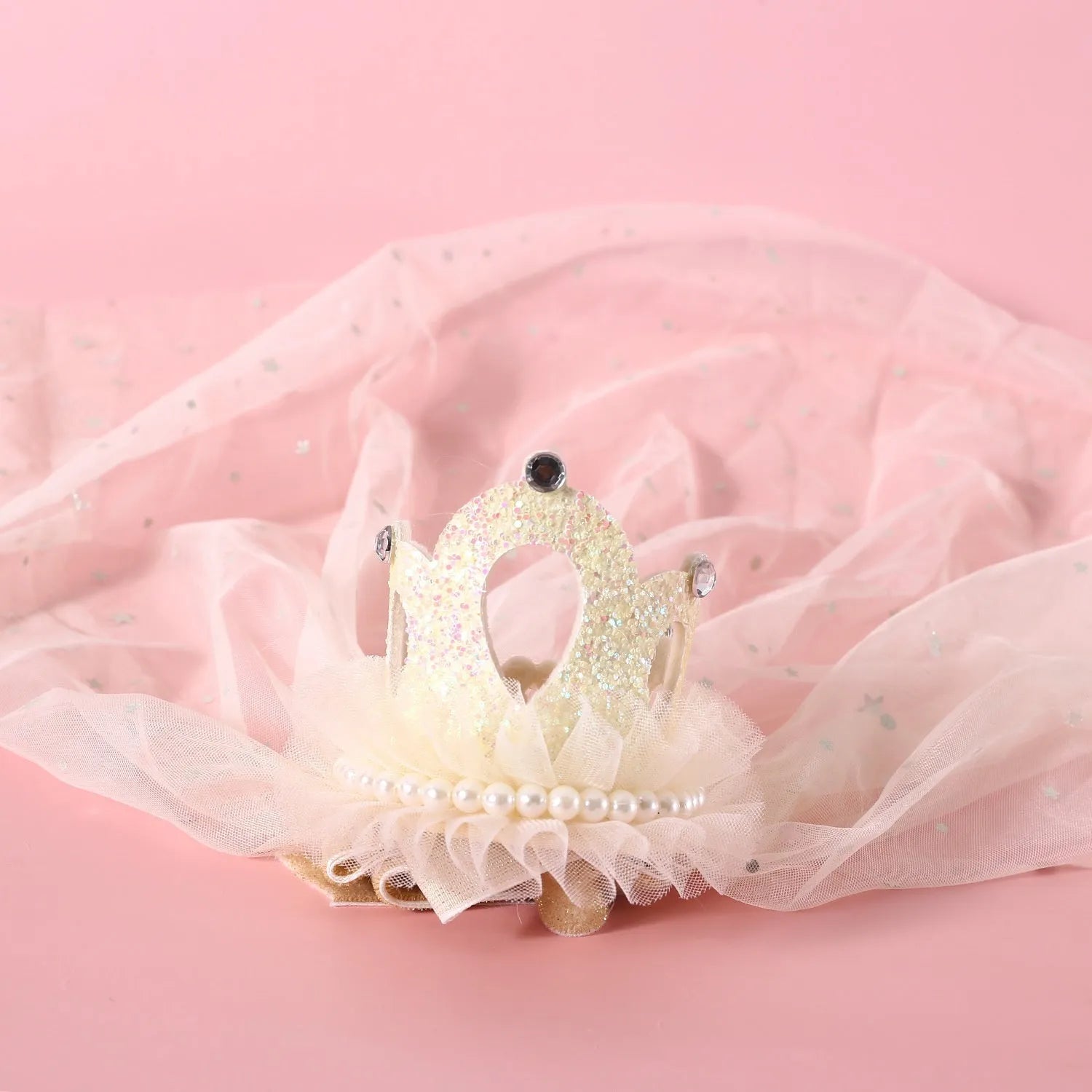 A cat wearing a princess crown headdress with a soft veil, available in beige or pink.