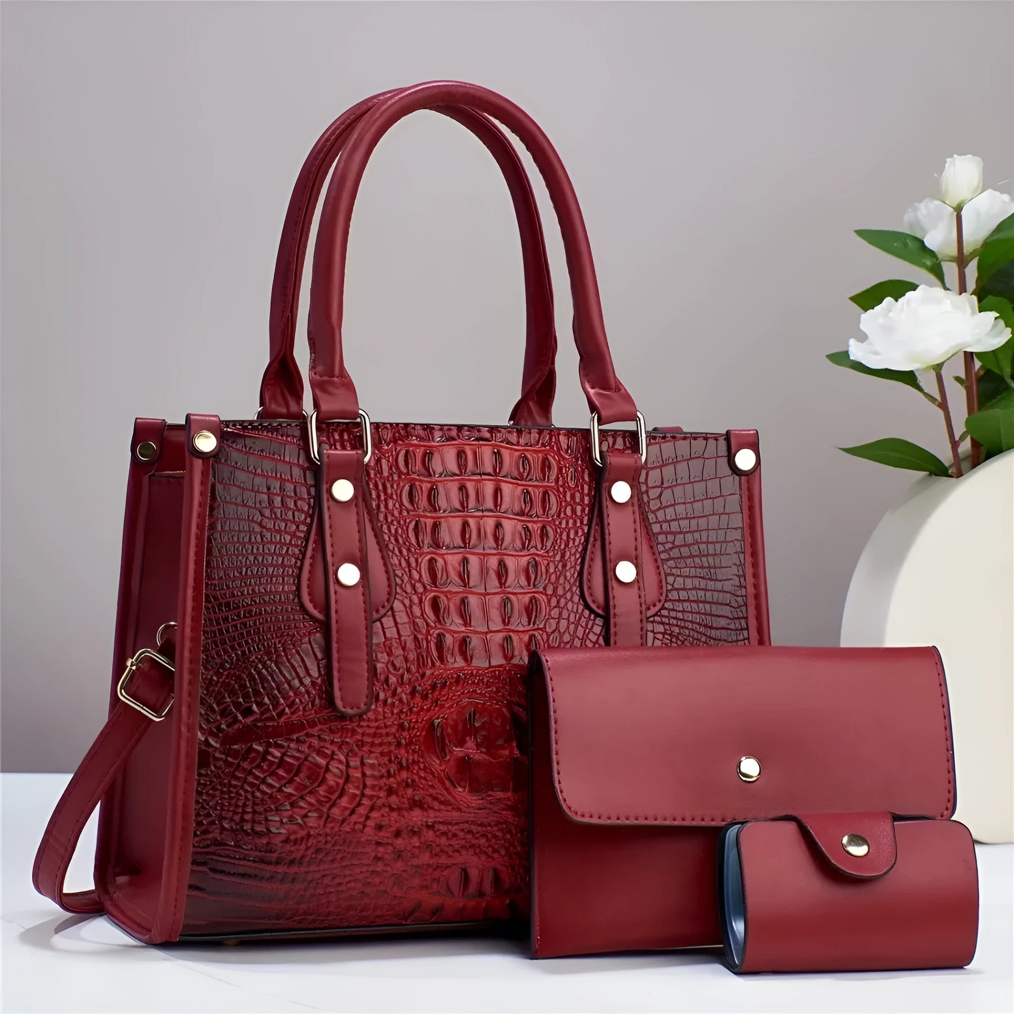Contrast colour minimalist textured three-piece set showing crossbody bag, wallet, and card holder in burgundy.