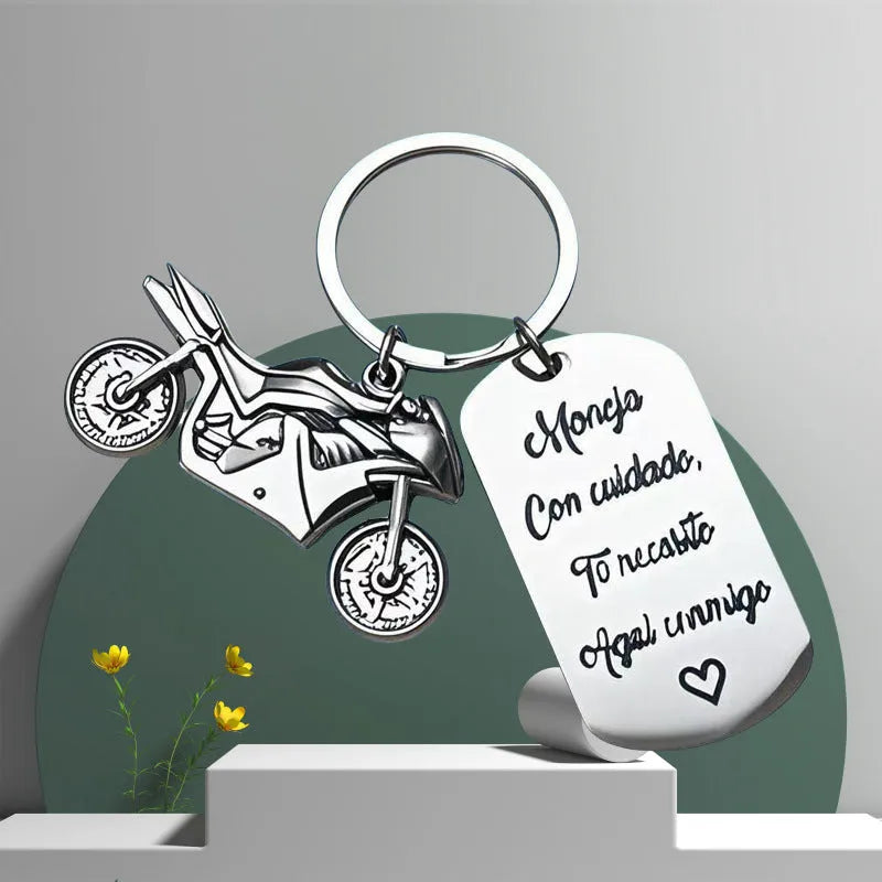 Stainless steel motivational keychain for motorcycle keys with a flannel storage bag.