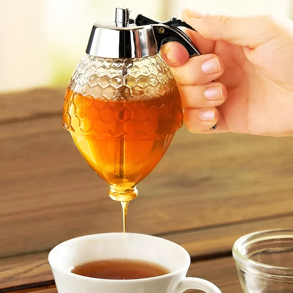 Transparent squeezable honey jar dispenser with 200ml capacity and bee design, sitting on a kitchen counter