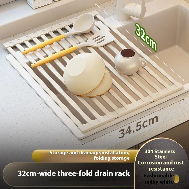 Milky White foldable stainless steel kitchen draining rack shown beside a sink, demonstrating its tri-fold mechanism.