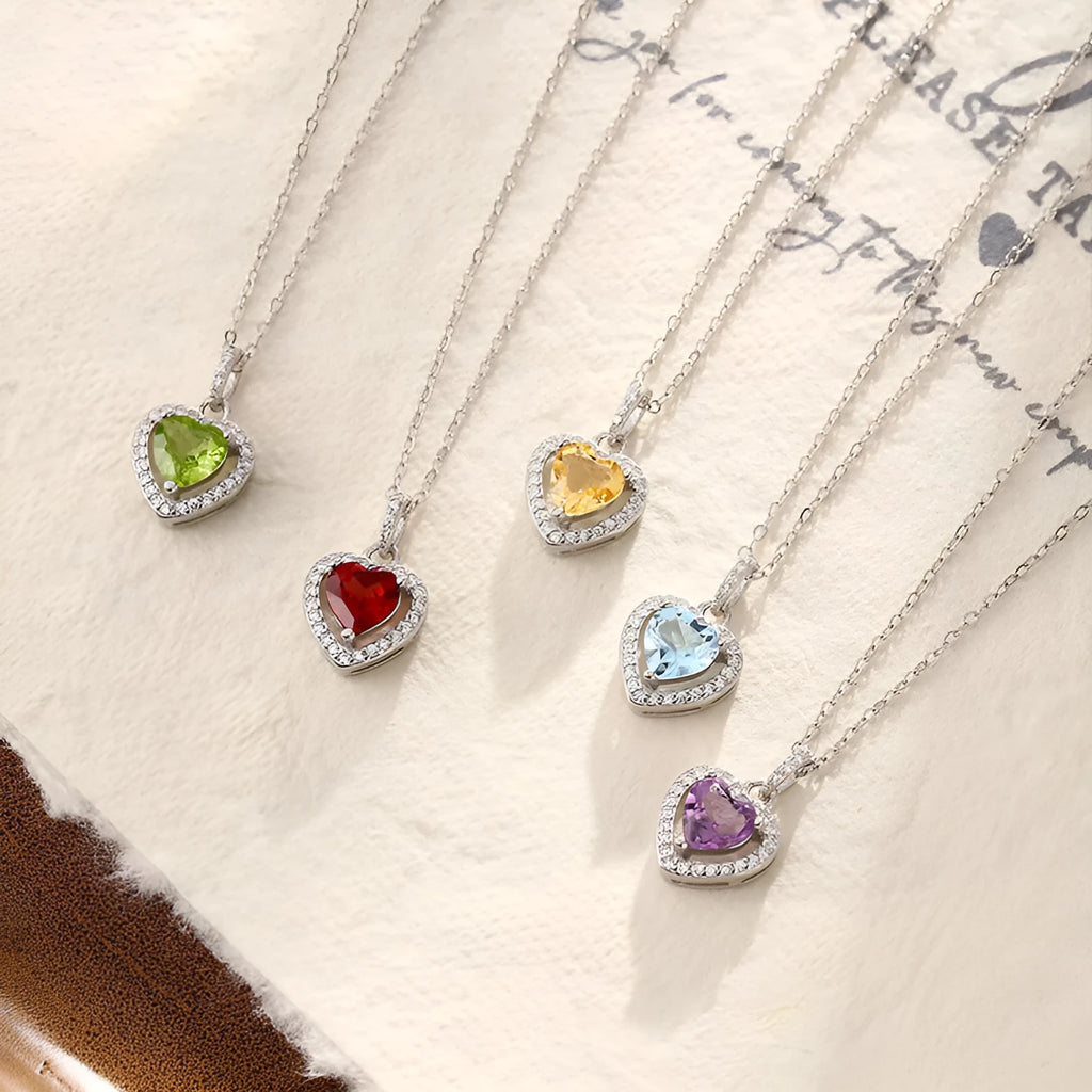 Women's sterling silver necklace with heart-shaped gemstone pendant on adjustable cross chain