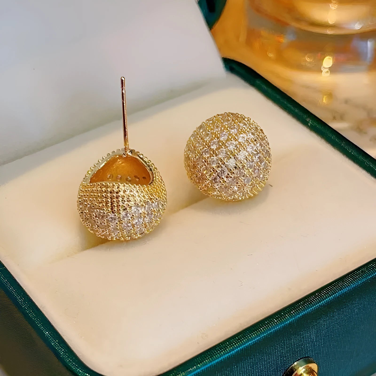 Geometric drop-shaped earrings with full diamond detailing, spherical elements, and little golden beans motif in gold or white colour