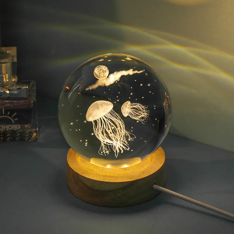 Transparent crystal ball night lamp with 3D carved jellyfish design, on a round base with USB cable.