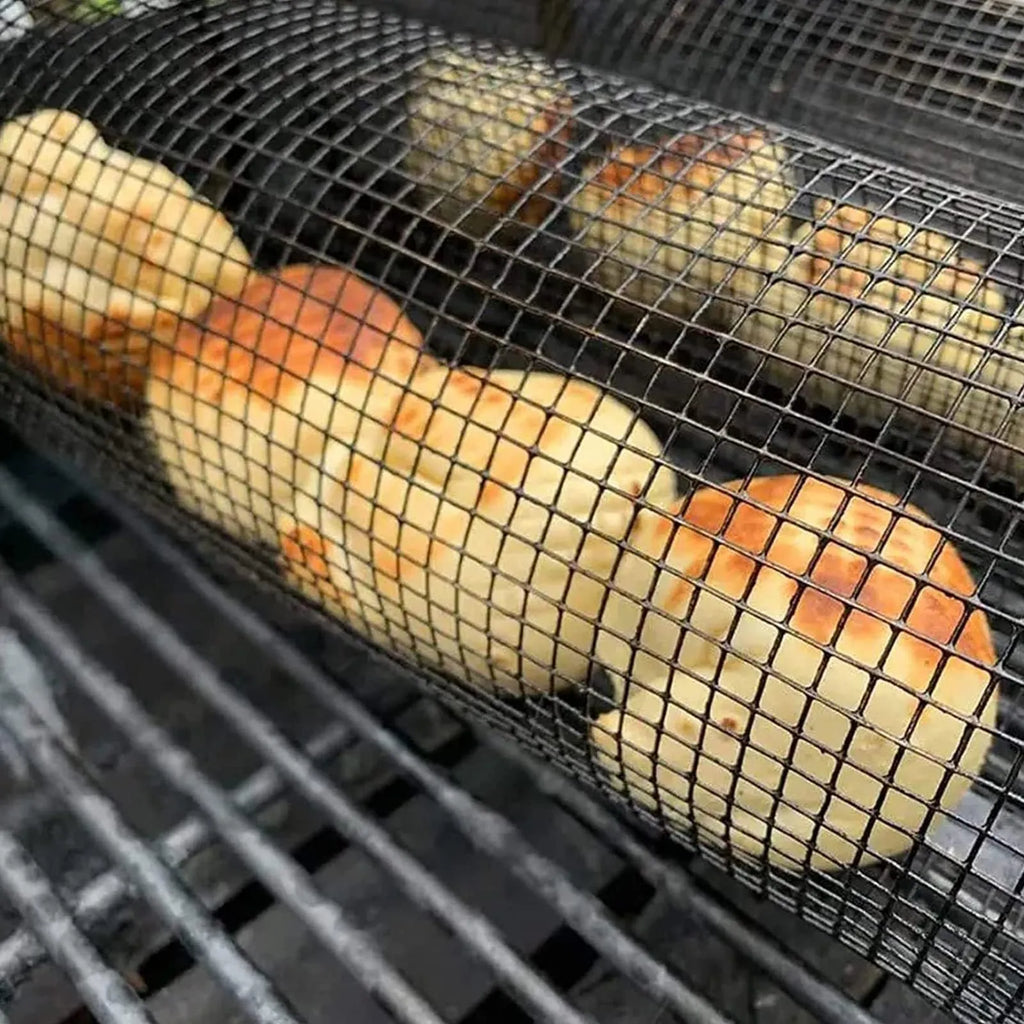 Round stainless steel rolling barbecue grilling basket with mesh sides and a hook, shown with assorted vegetables inside.