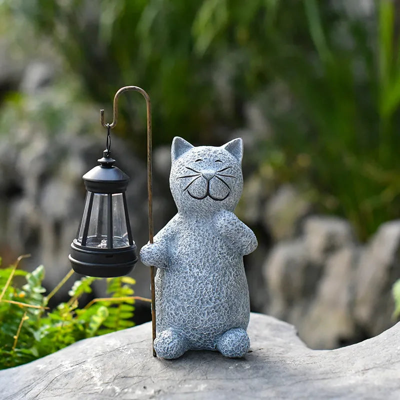 Solar-powered garden light with decorative resin kitten ornament lifting a lamp.