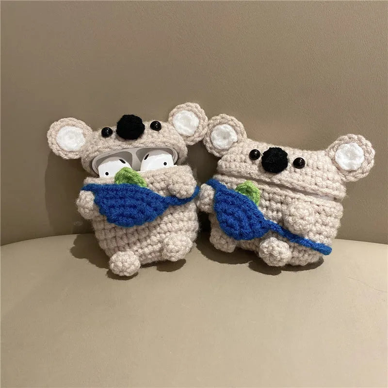 Handmade knitted AirPods case shaped like a backpack with koala ears on a blue background.