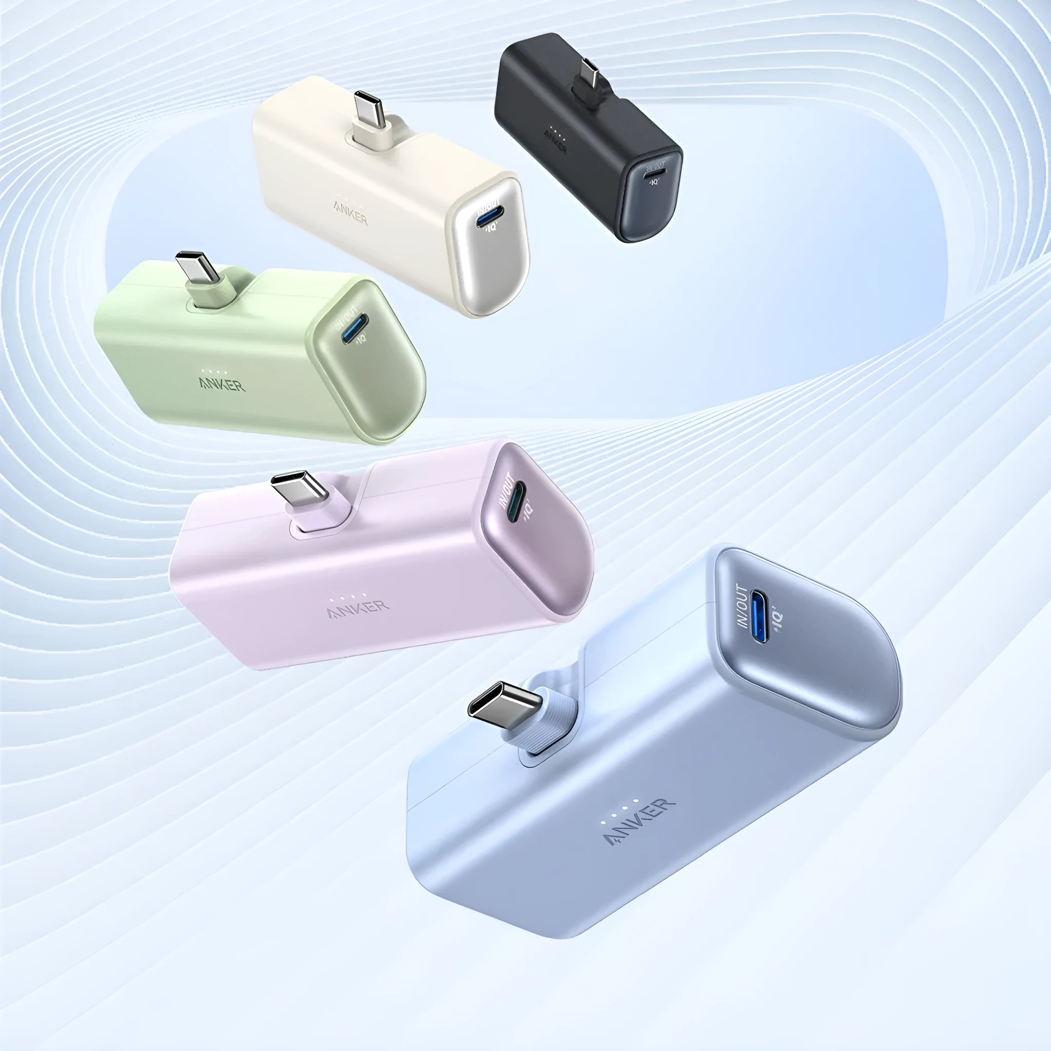 Small capsule-shaped power bank in multiple colours showing built-in foldable USB-C cable and compact size.