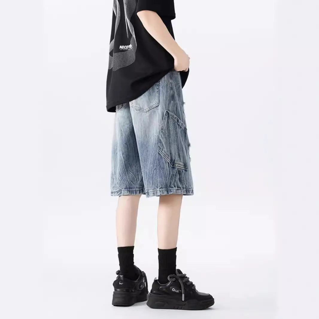 Men's washed denim shorts with ripped detailing in black or blue, showing loose retro style and fifth-pants length