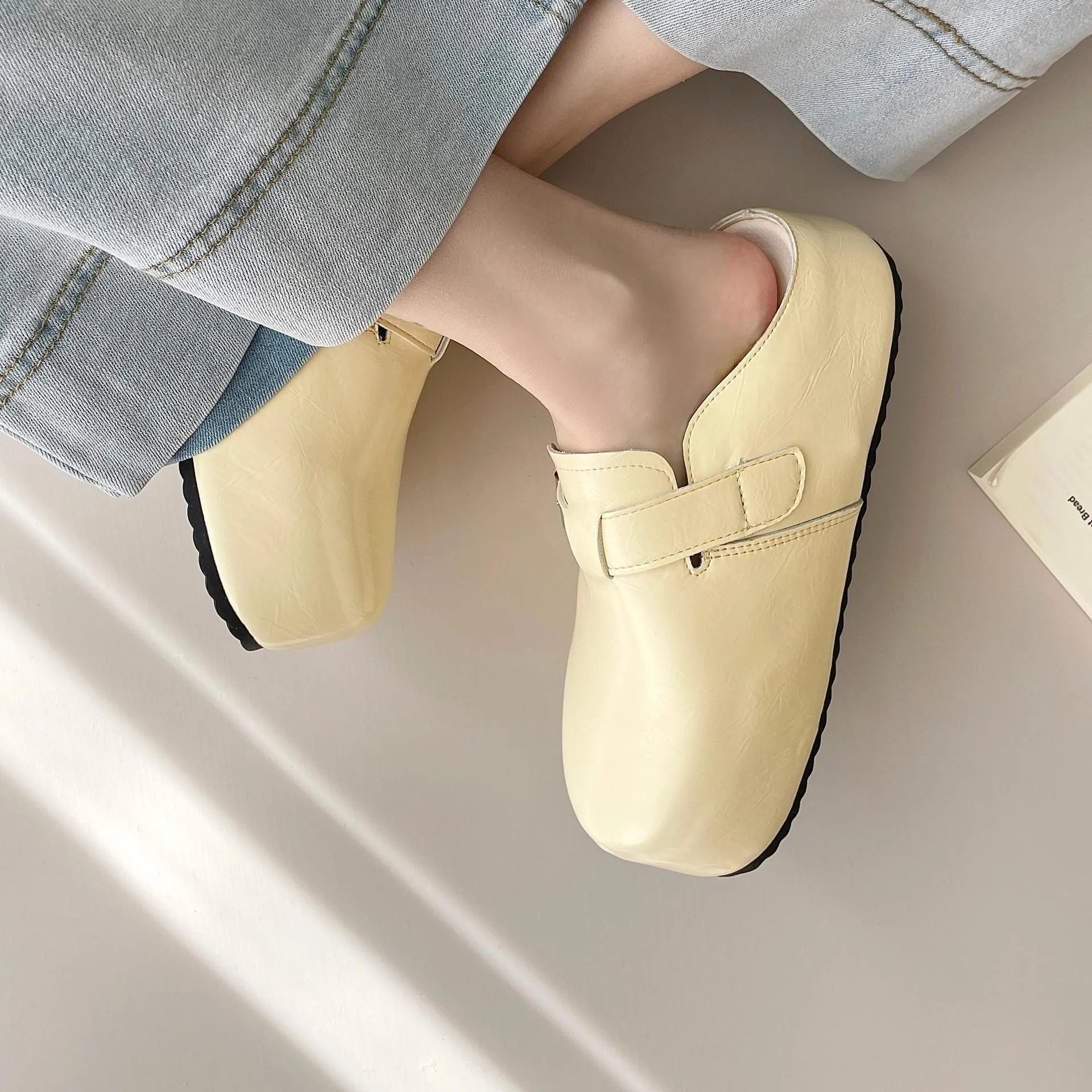 Flat buckle casual slippers with round toe and PU upper in beige colour on a clean surface