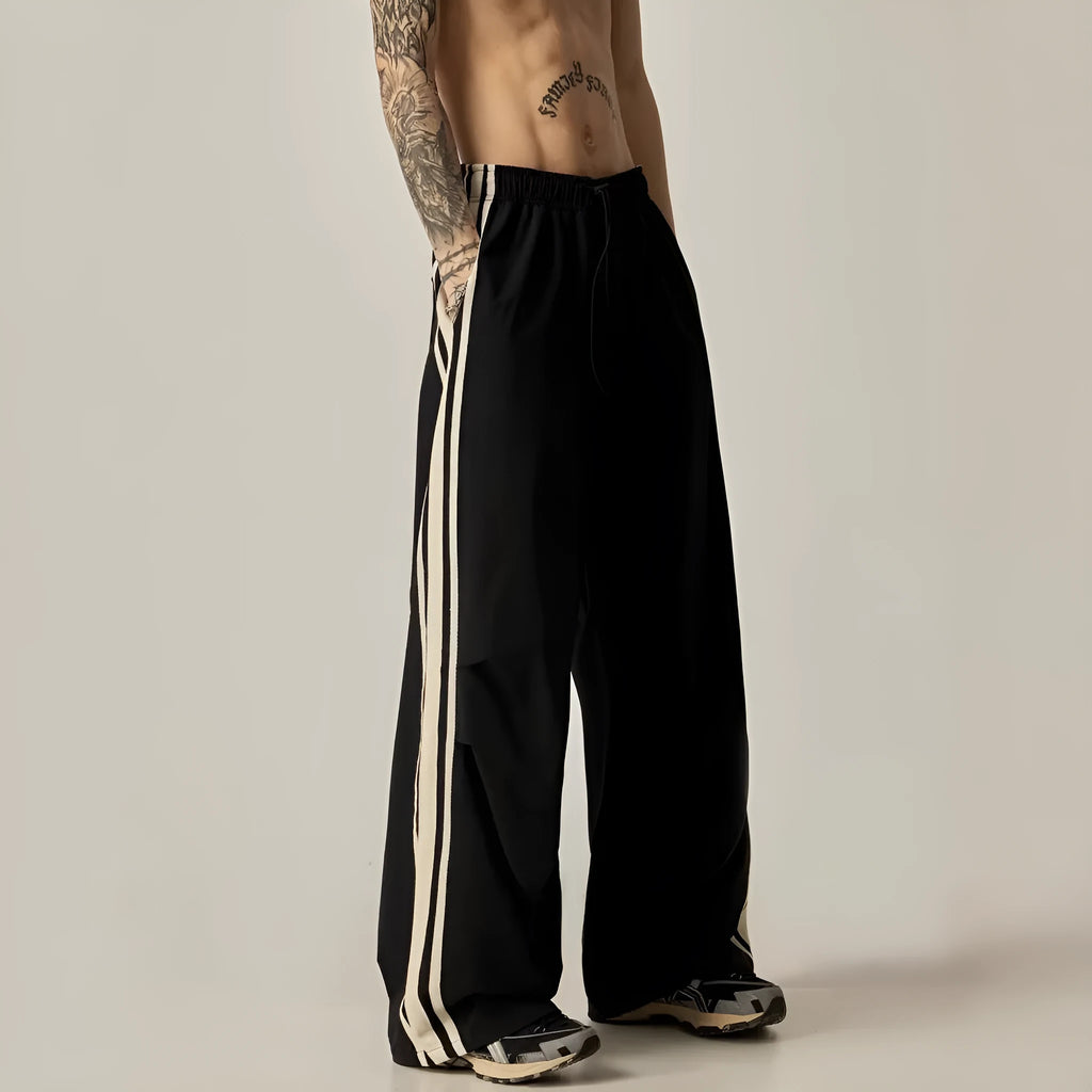 Black men's wide-leg high-waist climbing trousers laid flat, showing straight-leg cut.