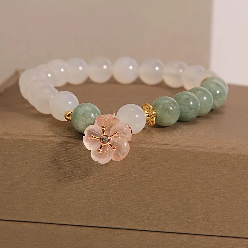 White agate jade flower bracelet with pink accent stones on wrist