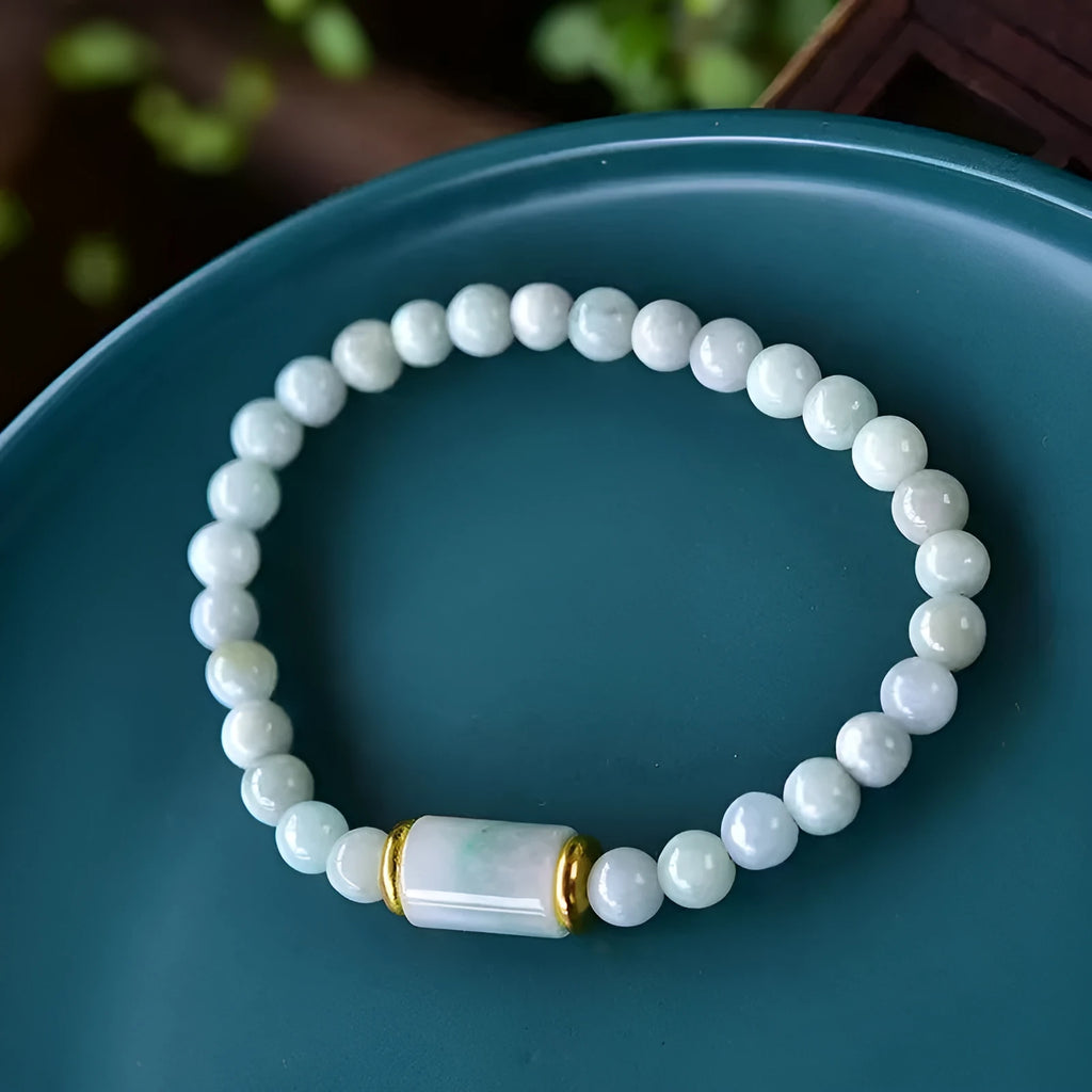 Close-up of a natural emerald green Myanmar jade stone bracelet with round lucky beads on a wrist.
