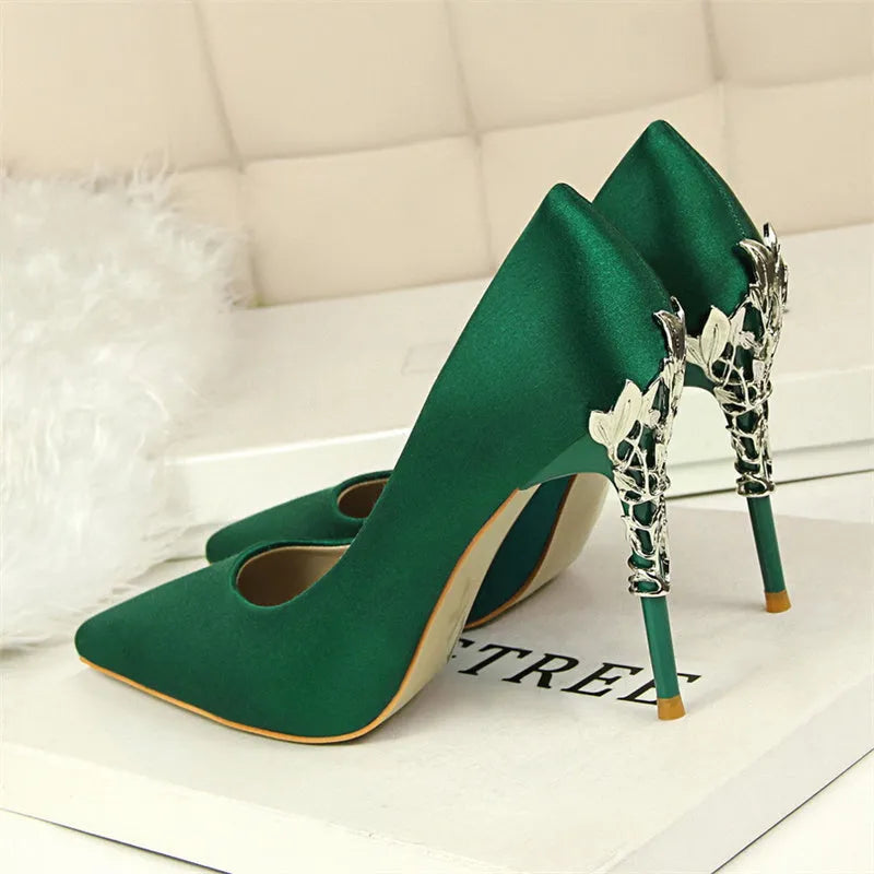 Pointy silver satin stiletto heels with 10cm heel and 1cm platform on neutral background