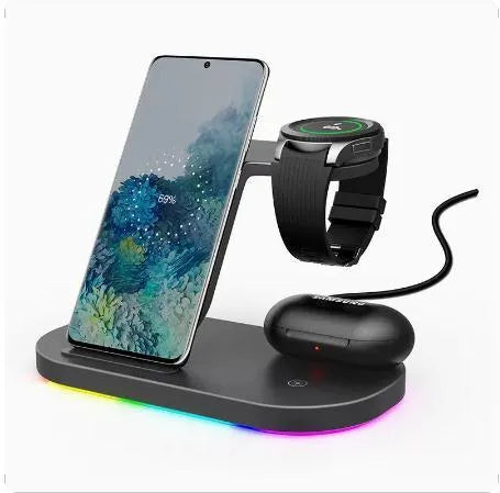 A vertical 3-in-1 wireless charging stand holding a mobile phone, a smartwatch, and headphones on a desk.