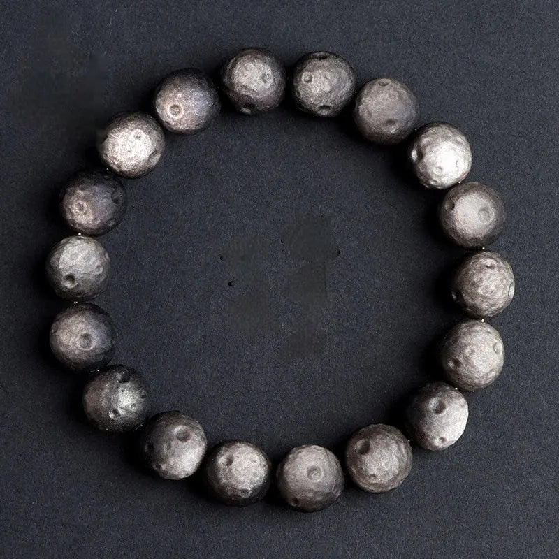 Natural obsidian crater ball bracelet in silver or gold finish, showing textured bead detail.