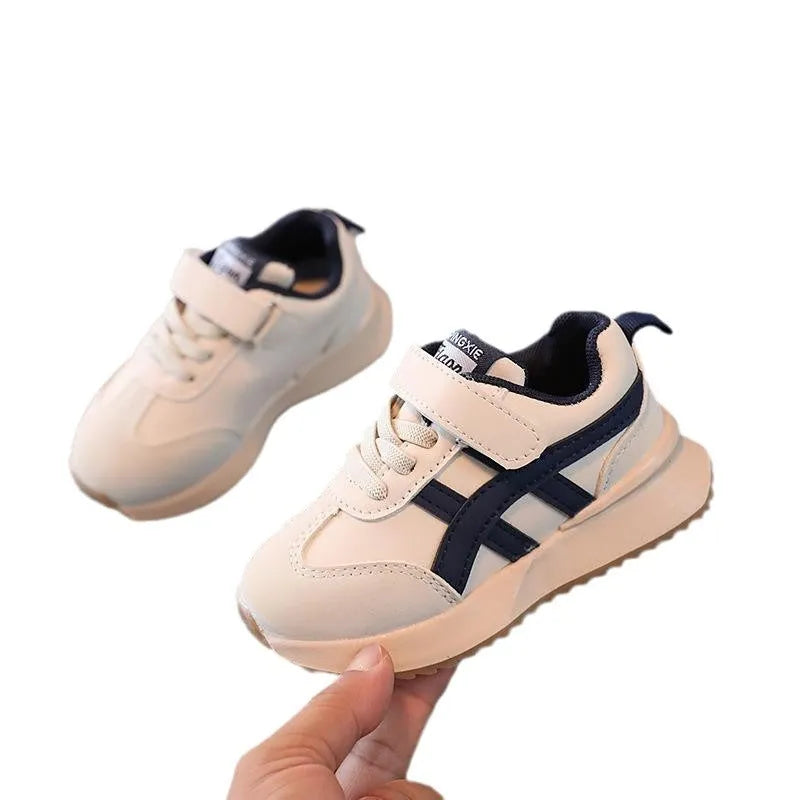 Children's white casual sneaker with Velcro strap and rubber sole, shown in sizes 21-30.