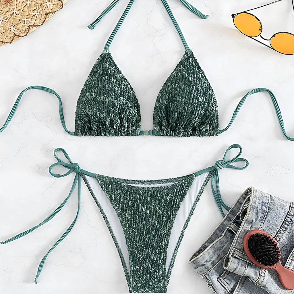 Green backless women's bikini set with halter neck strap and matching shorts.