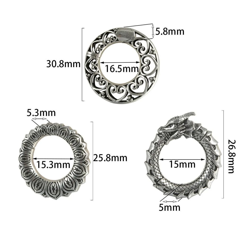 Pair of large antique silver dragon-shaped geometric ear cuffs with hollow-out detail on a plain background.