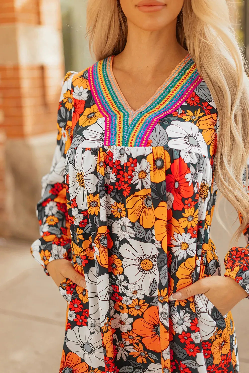 Orange floral print mini dress with lace trim, V-neck, and long sleeves on a hanger.