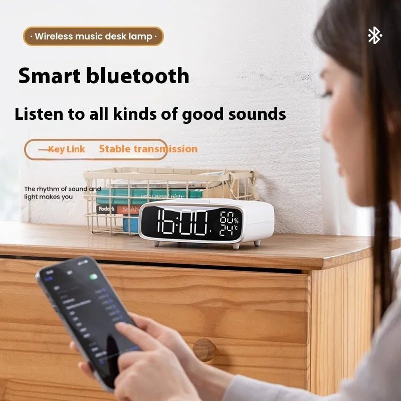 White wireless charger bluetooth speaker with LED night light and alarm clock display on flat surface