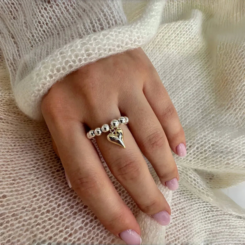 Handmade gold and white elastic beaded ring with a geometric love heart design.