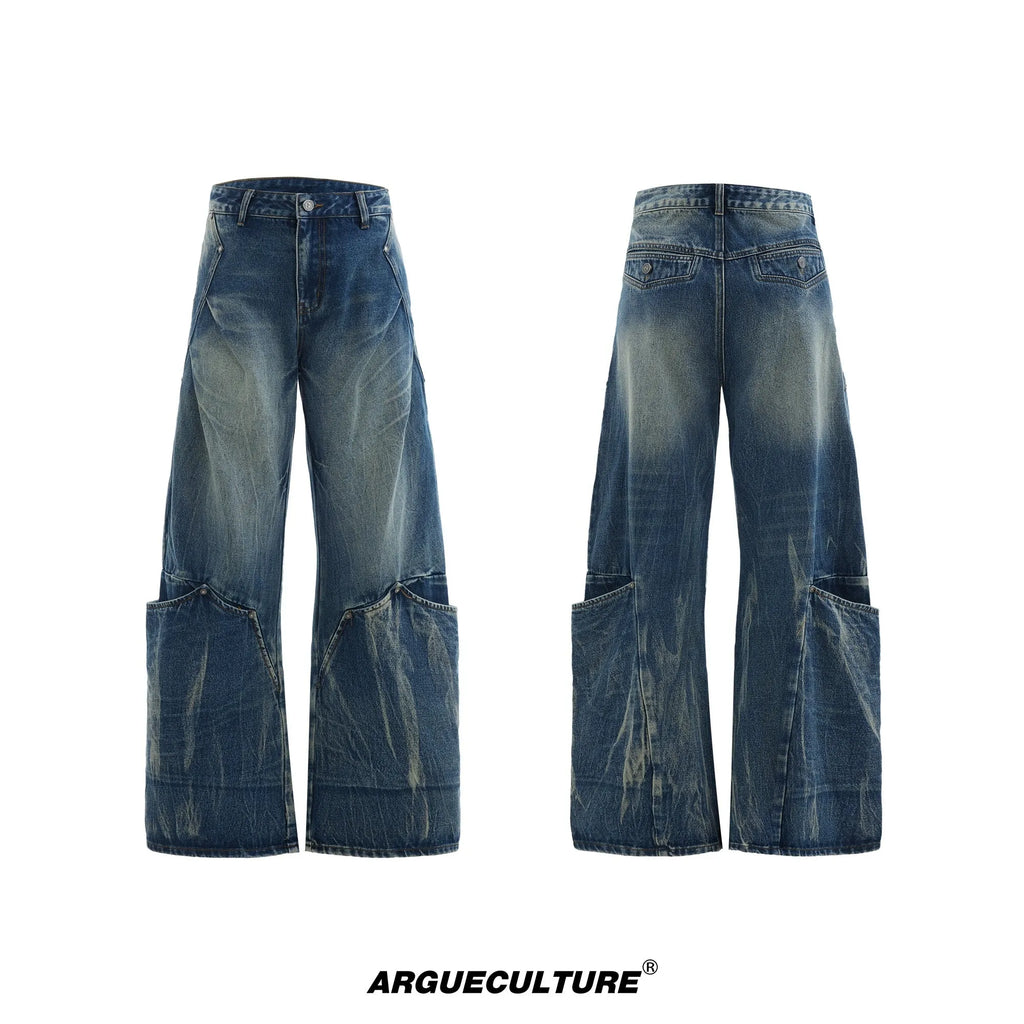 Man wearing verdant blue loose-fit retro jeans with a distinctive white burst pattern wash and a curved knife leg cut.