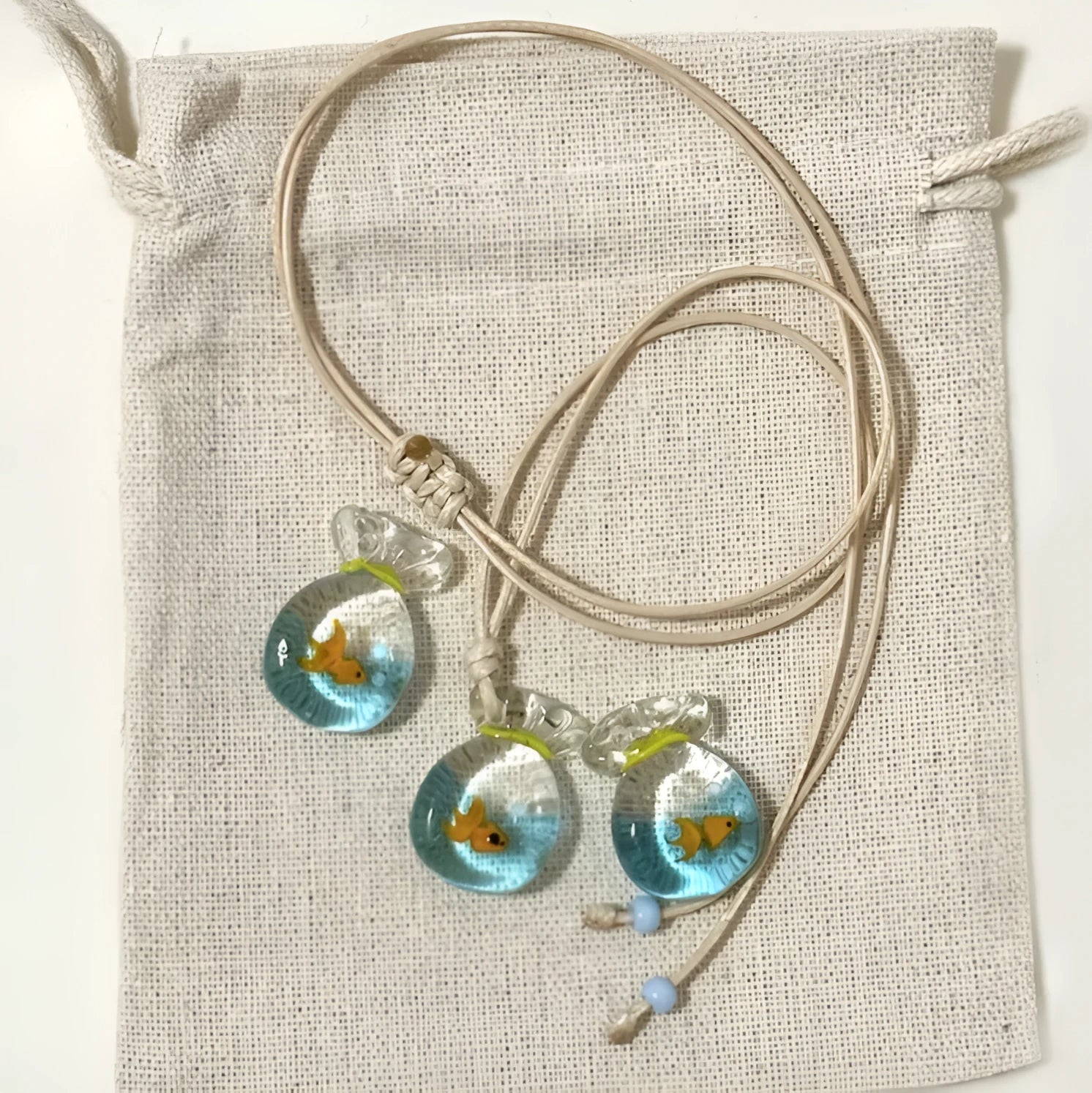 Women's necklace with a colourful skirt joker pendant on a long, braided cotton and linen chain.